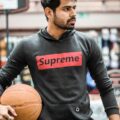 Portrait of a young man holding a basketball on an indoor court in Ahmedabad, India.